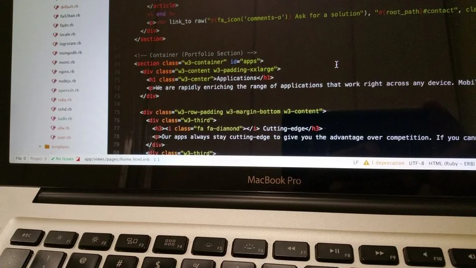 A close-up of a modern workspace, featuring a laptop and smartphone in use.